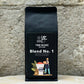 Ein Bild des Produkts Blend Number one von True Beans auf einem Holztisch vor einer steinernen Säule.