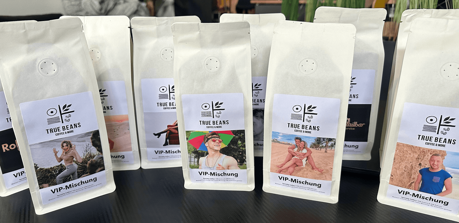 Mehrere Verpackungen von True Beans VIP-Mischung Kaffee, jede mit einem individuellen Etikett, das verschiedene Personen in unterschiedlichen Umgebungen zeigt.