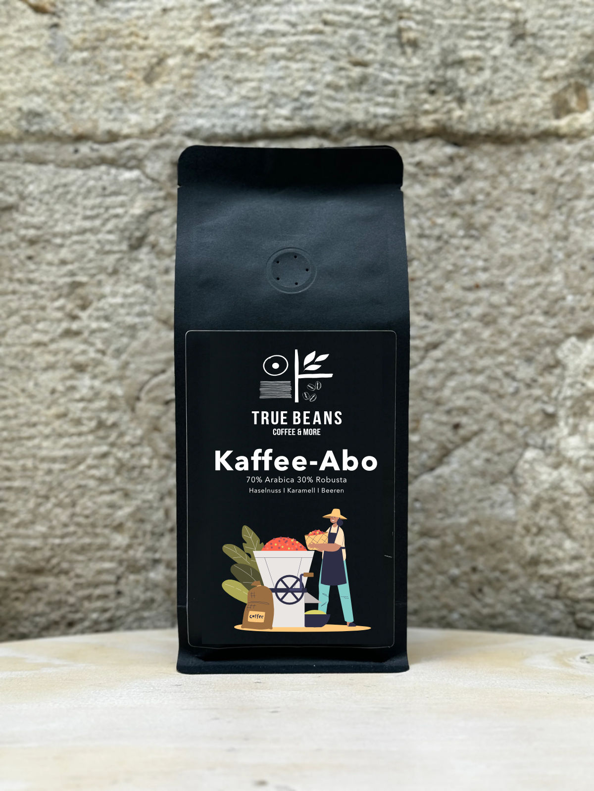 Schwarze Kaffeeverpackung von True Beans mit Etikett ‚Kaffee-Abo‘ – 70 % Arabica, 30 % Robusta, Geschmacksnoten von Haselnuss, Karamell und Beeren. Frisch gerösteter Spezialitätenkaffee aus nachhaltigem Anbau, erhältlich im Kaffee-Abo im True Beans Online-Shop.