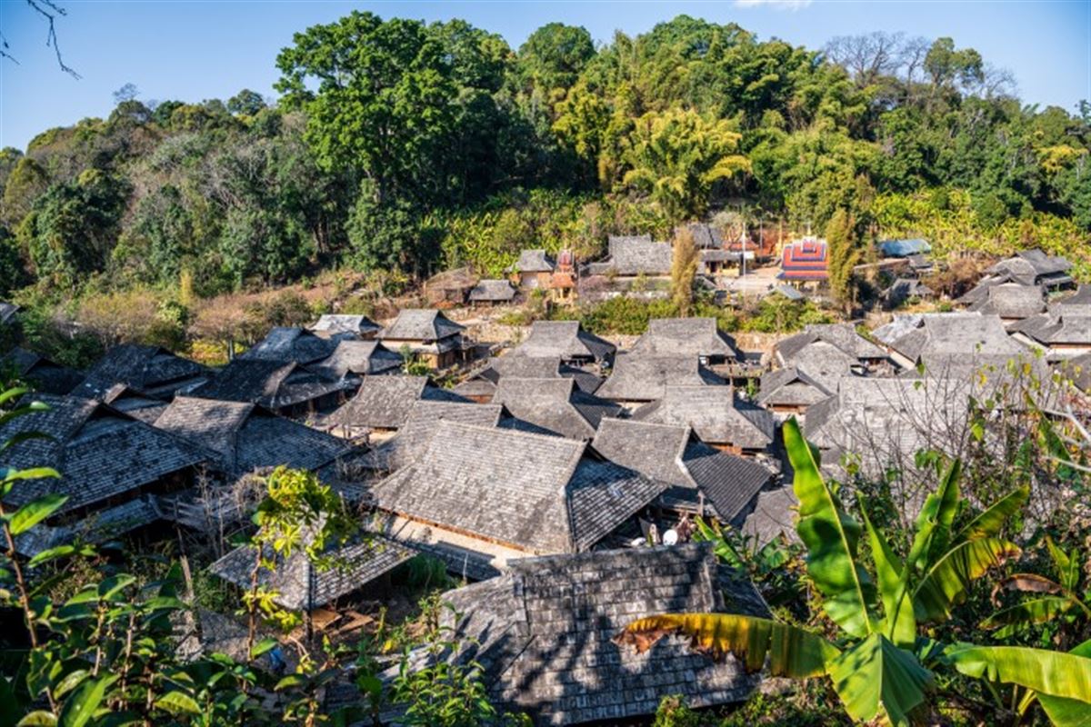 Kaffee aus China – traditionelle Kaffeefarm in Yunnan mit kleinen Farmhäusern inmitten dichter, grüner Vegetation.